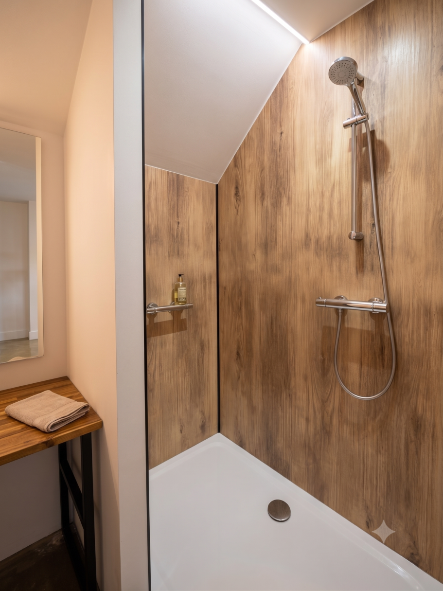 Douche d'angle chaleureuse Douche moderne avec paroi en verre et murs en bois, lavabos en bois à côté.